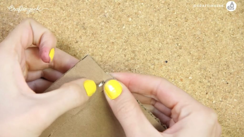 Juntar piezas de cartón con broche mariposa.